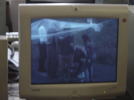 [Photo: Screen-shot of the outdoor barbecue scene from the Unconventional 2002 video]