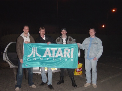 [Photo: F2 and MNX holding Atari banner]