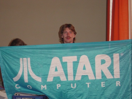 [Photo: TXG hiding behind his Atari flag]