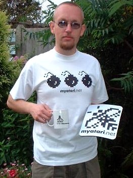 [Photo: Matthew sporting a MyAtari t-shirt, mouse-mat and mug]