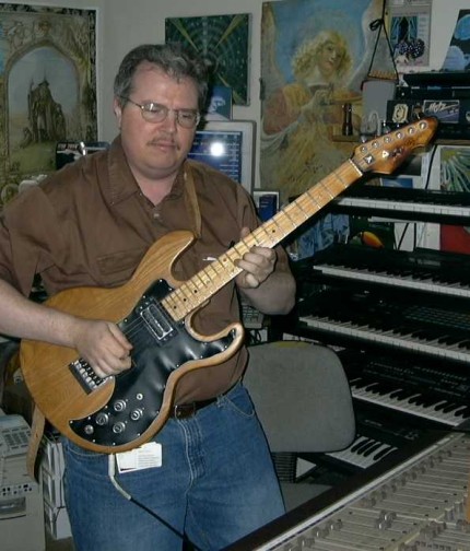 [Photo: Tim playing his guitar]